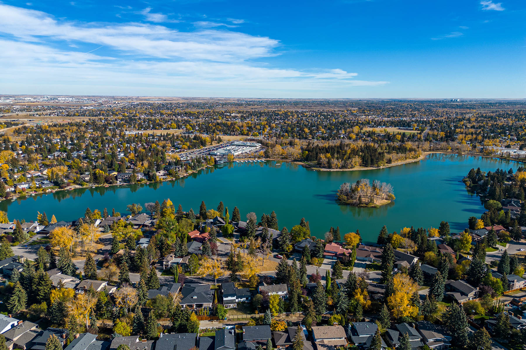 Aerial photograph above Lake Bonavista in summer, a beautiful Calgary lake community.